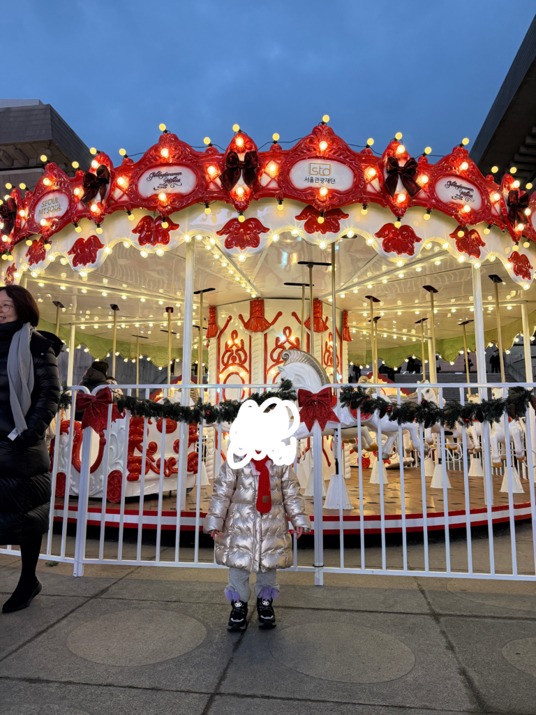 Illuminated carousel at the Gwanghwamun Christmas Market in Seoul at dusk
