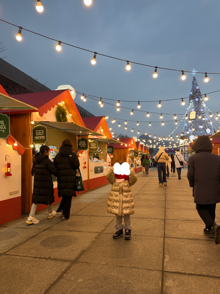 Illuminated market stalls and giant Christmas tree at the Gwanghwamun Christmas Market at dusk in Seoul