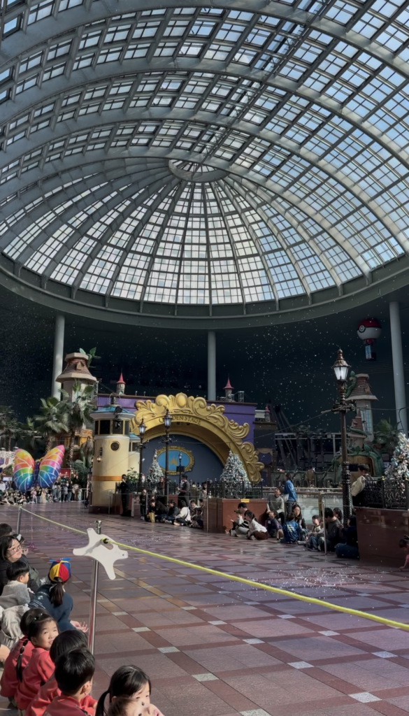 Interior glass dome of Lotte World with kids watching the parade at the indoor theme park in Seoul