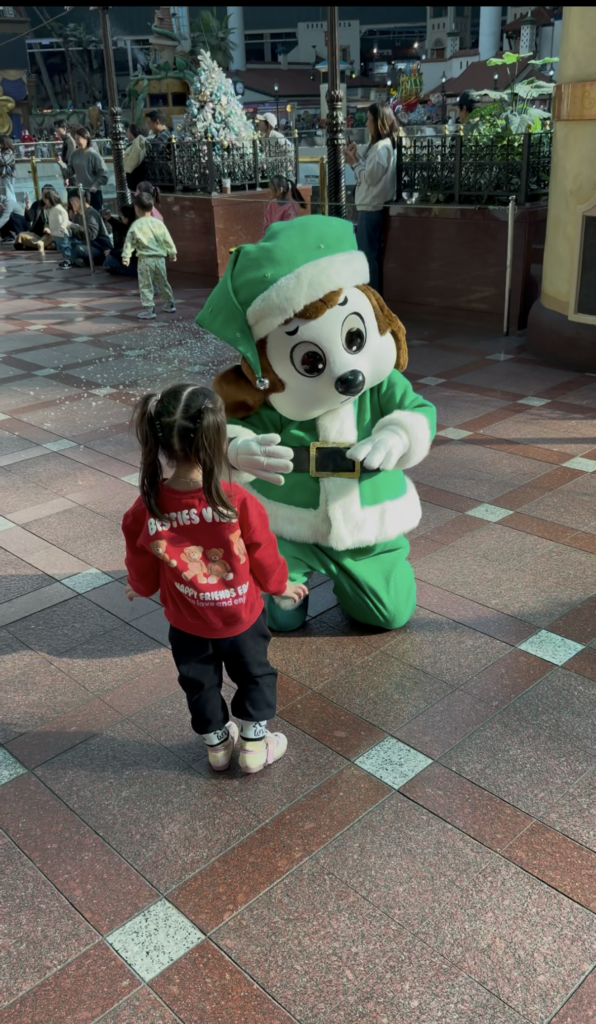 Toddler meeting a costumed character mascot at Lotte World during the winter season in Seoul