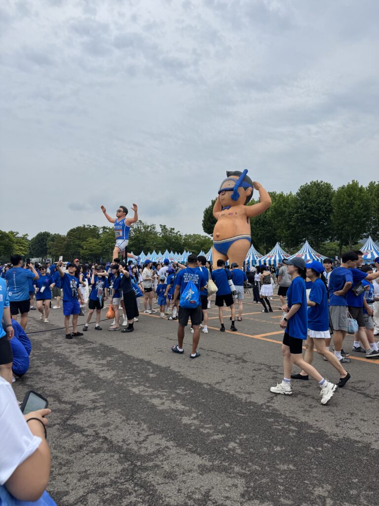 Crowd in blue outfits and giant inflatable PSY figures at Summer Swag 2026