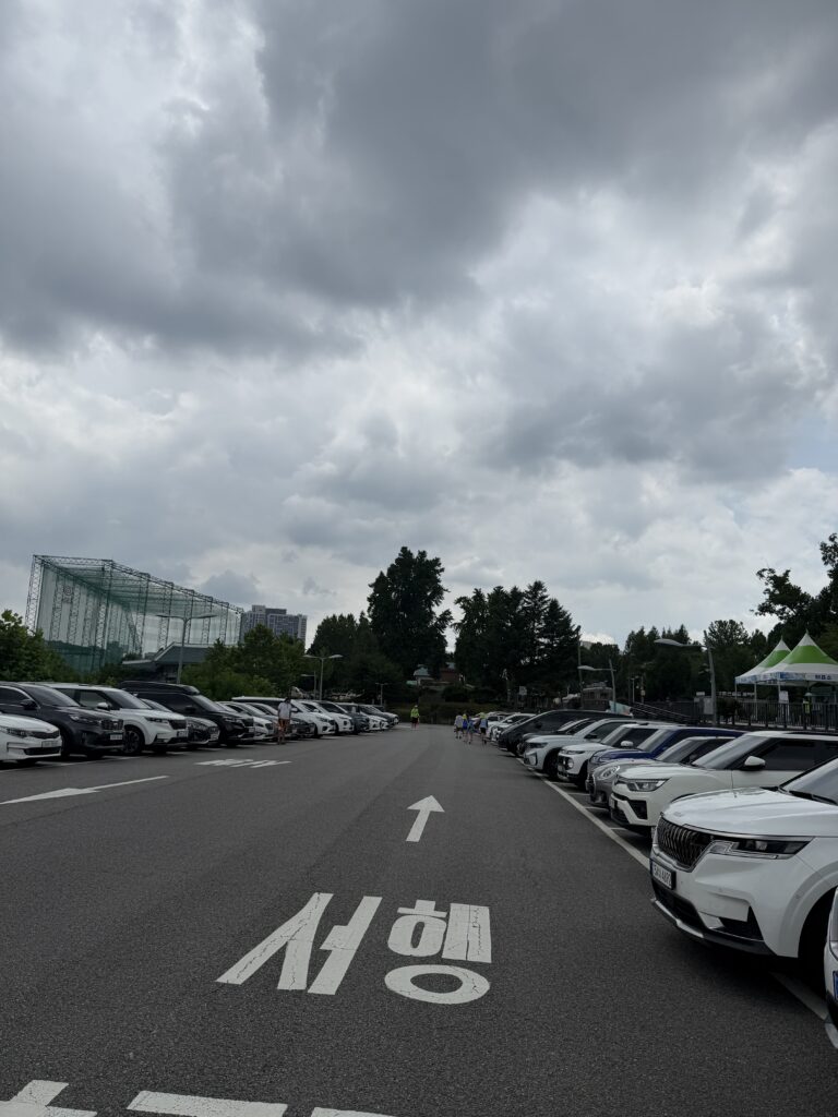 Parking lot at Hwarangdae Railroad Park with cars and greenery