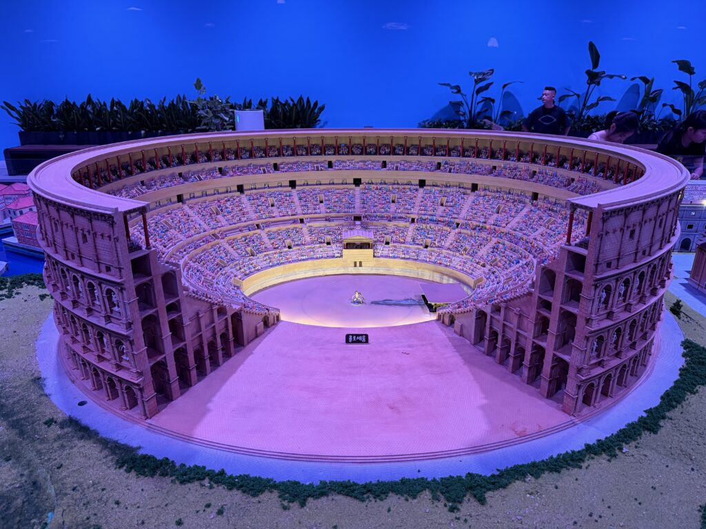 Miniature model of the Roman Colosseum under pink lighting at Nowon Train Village Italy Hall