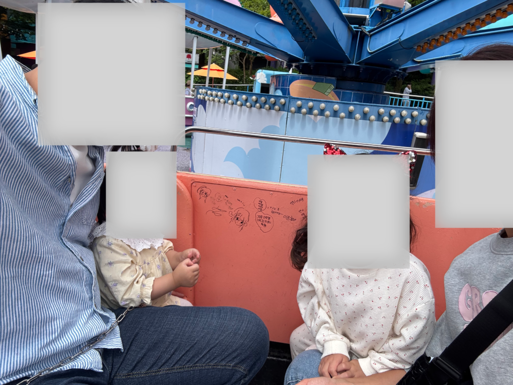 Parents and young children riding a gentle spinning ride at Seoul Land