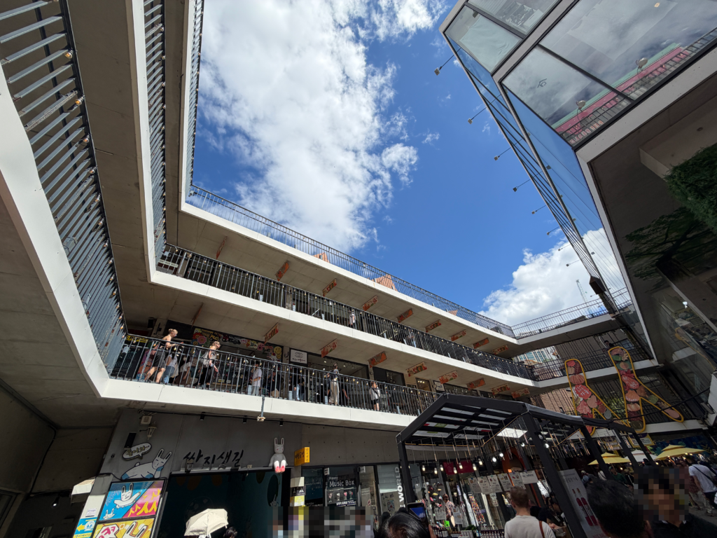 Upward view of the open courtyard at Ssamzigil showing the ramped walkways spiralling around four levels of shops