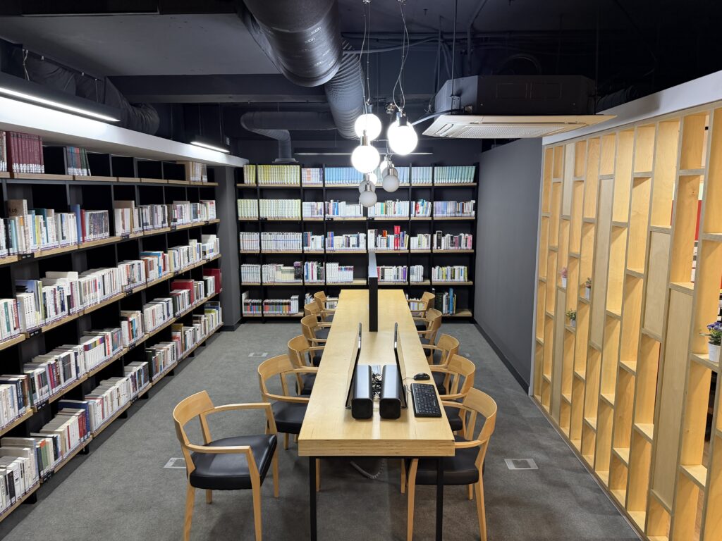 The library on the second floor of the Seoul City Wall Museum, with bookshelves and a long reading table