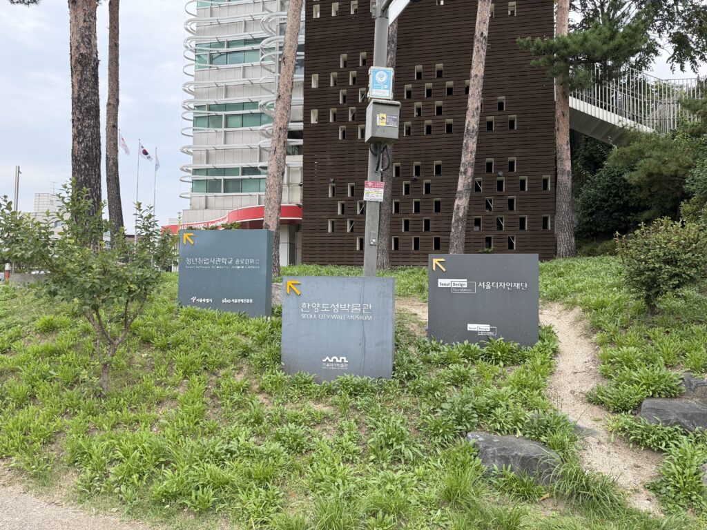 Directional signs outside the Seoul City Wall Museum in Jongno-gu, pointing to the museum and the Seoul Design Foundation