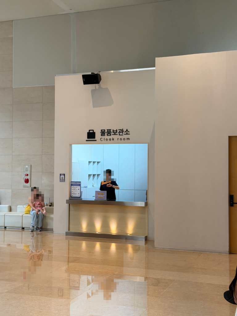 Staffed Cloak Room counter with bilingual Korean and English signage at the National Museum of Korea, Seoul.