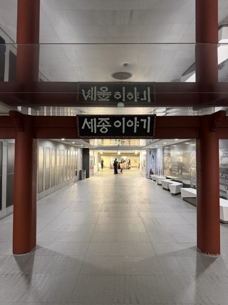 Red pillared gateway marking the entrance to The Story of King Sejong in the underground corridor beneath Gwanghwamun Square