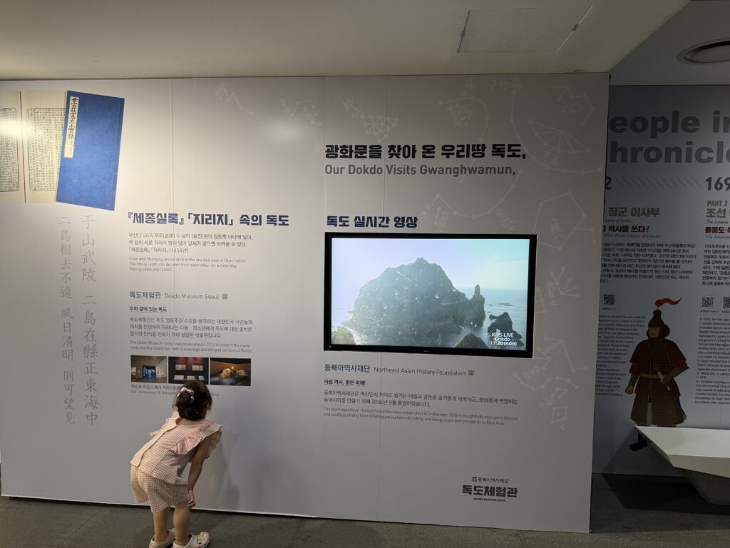 Young child looking at a live video feed of the Dokdo islets on a display wall at the Dokdo Experience Center, Gwanghwamun