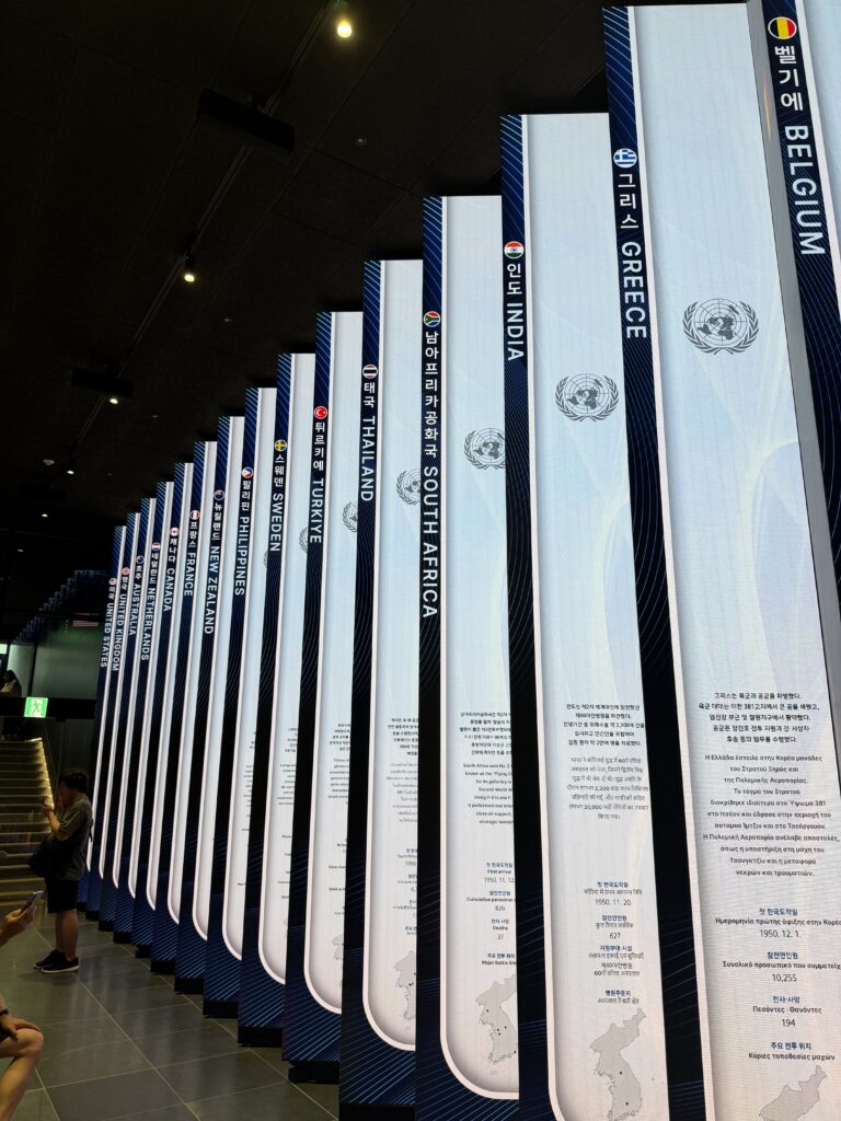 Row of illuminated LED pillars in Freedom Hall, each showing the flag and name of a nation that supported South Korea in the Korean War
