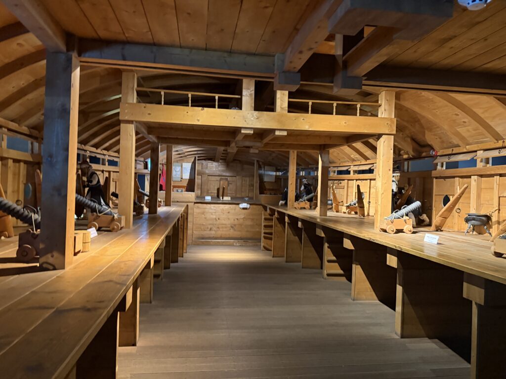 Interior of the panokseon replica showing rows of wooden cannons along both sides of the gun deck